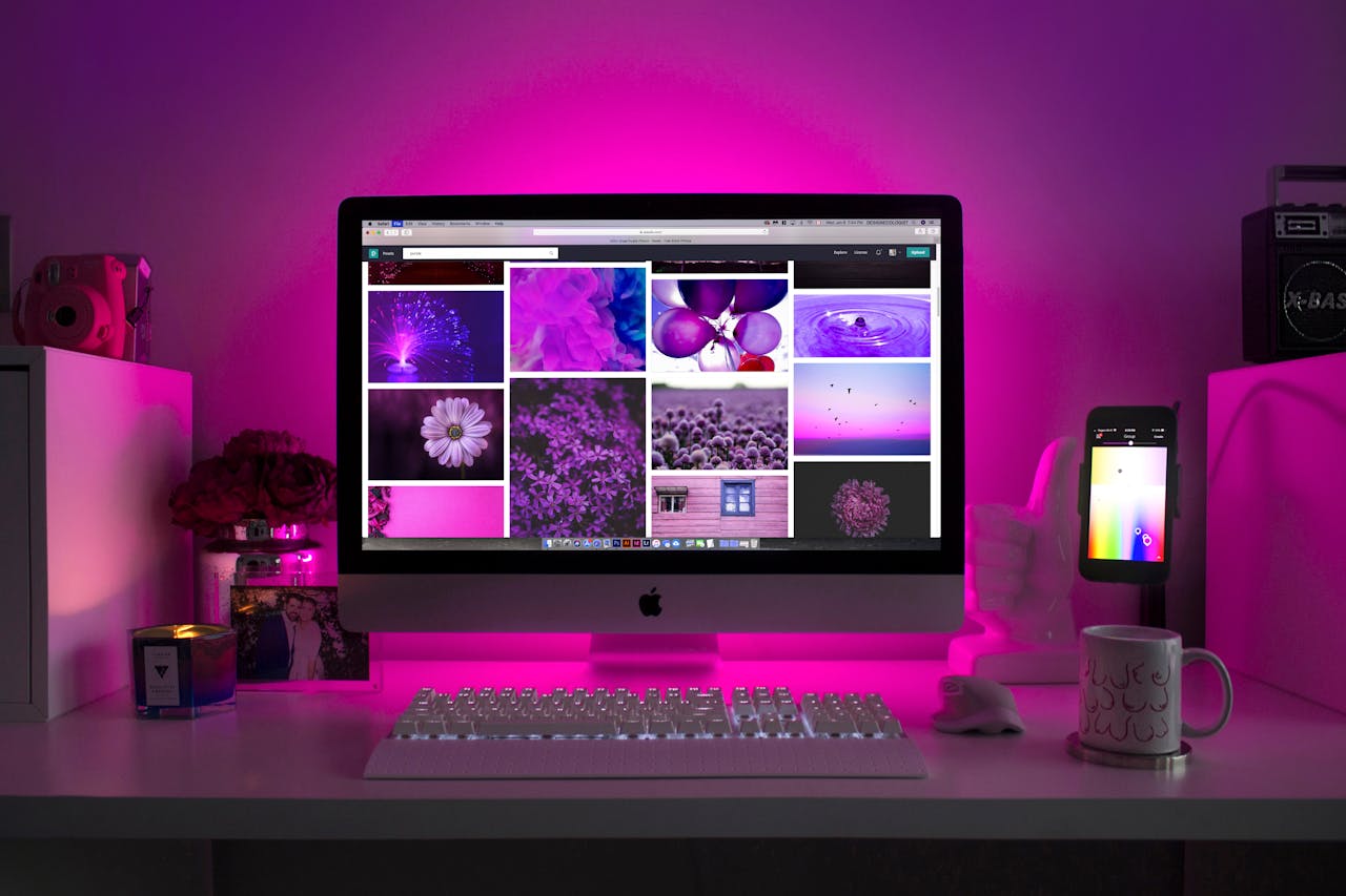 about-us Modern desk setup with neon lighting and a desktop computer displaying colorful images.