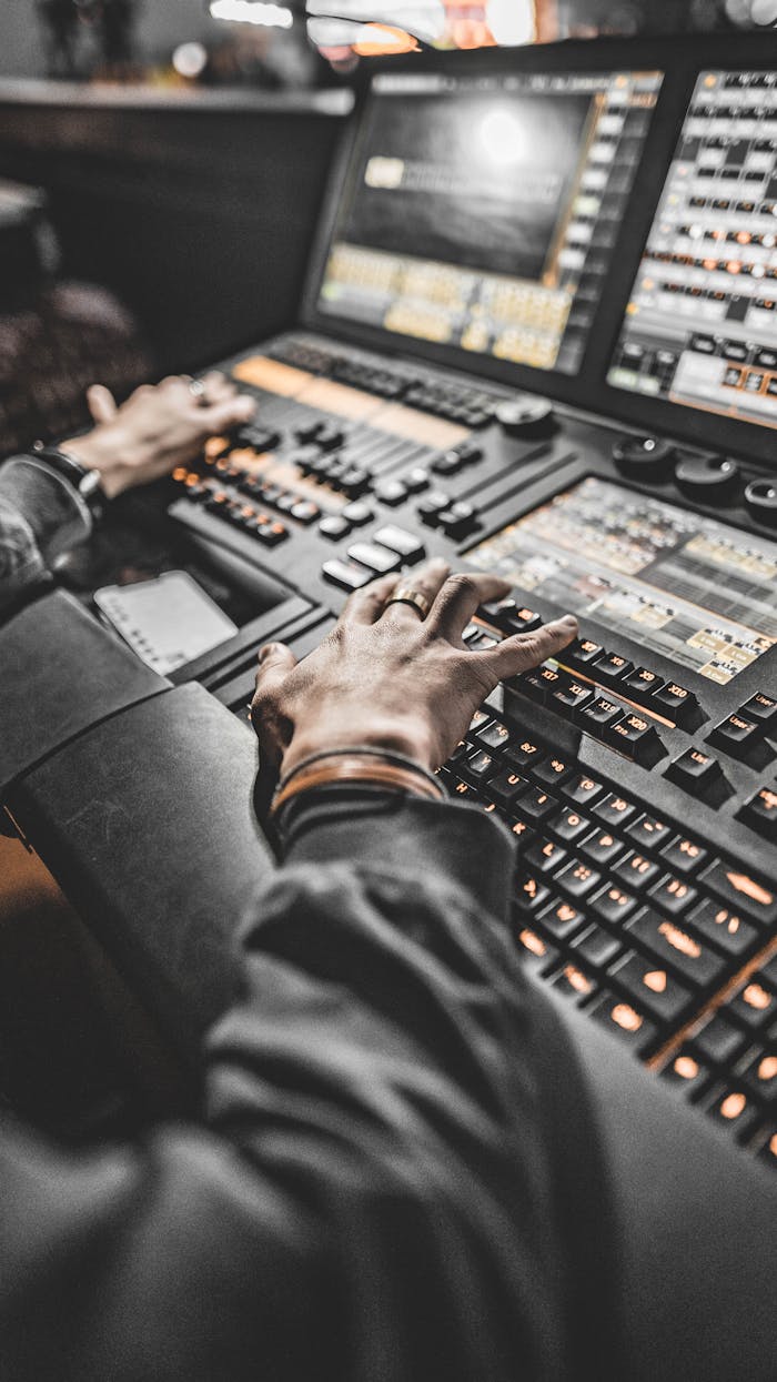 Close-up of a technician operating advanced lighting control panel in a studio.